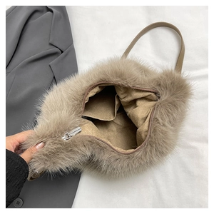 Detail view of the inner lining and silver zipper pocket of the light brown plush handbag