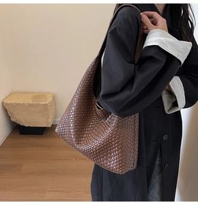 Close-up of deep brown hobo bag featuring premium woven texture and wide shoulder strap