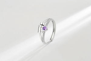 Detail of anxiety ring with spinning cylinders and heart-shaped purple gemstone