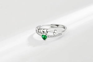 Macro shot of silver spinning ring with green heart crystal and pavé rhinestones