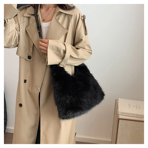 Detail of black faux fur shoulder bag worn with khaki trench coat for autumn style