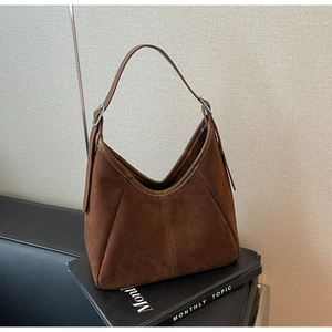 Detail of dark brown suede tote bag with adjustable strap and silver metal hardware