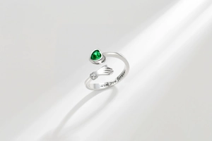 Detail of silver hug ring with green heart stone and love you forever engraving