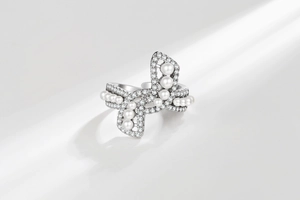 Detailed close-up of bow ring with shimmering pearls and sparkling cubic zirconia stones