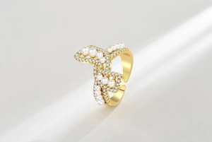 Close-up of adjustable bow ring with white pearls and sparkling cubic zirconia stones