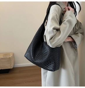 Detailed view of black woven leather texture on a large minimalist commuter tote bag