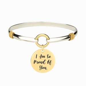 Dettaglio del bracciale bicolore con ciondolo rotondo inciso 'I Am So Proud Of You'