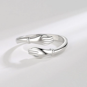 Minimalist silver hug ring with adjustable open band featuring a romantic hand-holding design
