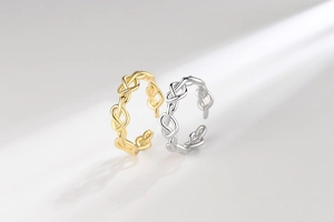 Detail of woven chain link rings in gold and silver finish with adjustable open design