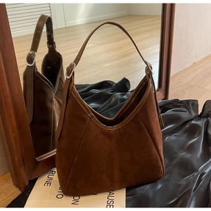 Detail of vintage brown frosted hobo bag showing vertical stitching and silver buckles
