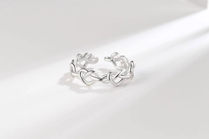 Macro shot of silver interlocking heart chain ring with adjustable open design
