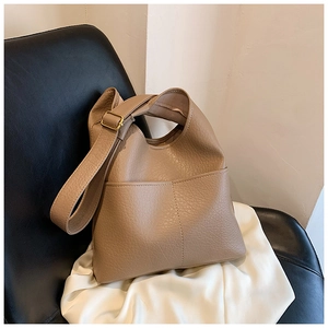 Detail of khaki tote bag featuring lychee texture faux leather and golden buckle strap