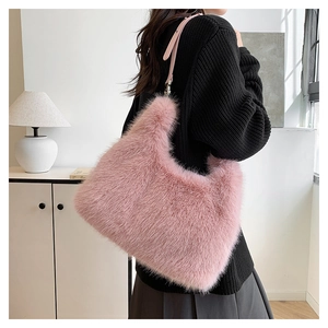 Detail of pink faux fur tote bag with slim leather strap worn by a model in a minimalist room