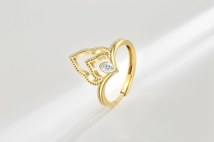 Detailed view of a gold-plated flame ring with marquise-cut crystal and beaded edge
