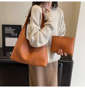 Detail of a brown woven leather hobo bag and matching pouch worn with an elegant outfit