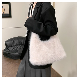 Detail shot of light pink fuzzy plush shoulder bag texture with leather strap on a model