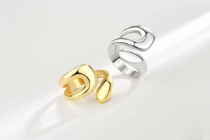 Detail view of irregular fluid gold and silver rings with high-polish mirror finish