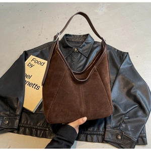 Detail of deep brown frosted suede texture and silver buckle on large tote bag