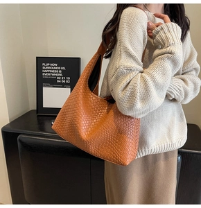Detail of caramel woven leather shoulder bag showing the premium texture and Hobo design