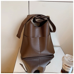 Close-up of deep brown lychee texture leather shoulder bag with detailed stitching