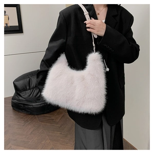 Detail of minimalist faux fur shoulder bag in creamy white on a model with black blazer