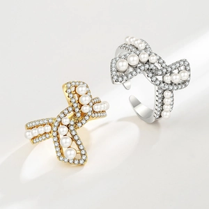Elegant bow-shaped open rings with pearls and zircons in gold and silver finishes