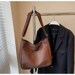 Detail view of deep brown large tote bag with lychee texture and side pocket