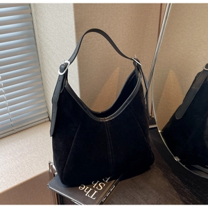 Detail of black suede tote bag showing silver metal buckle and textured leather finish