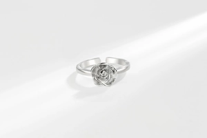 Macro detail of silver rose ring showing realistic petals and adjustable mirror finish band