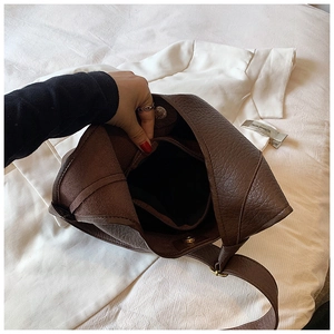 Detail of spacious brown tote interior with lychee texture and magnetic snap closure