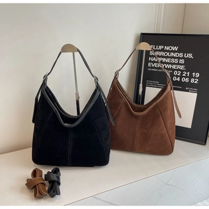 Detailed view of matte suede tote bags in black and brown with adjustable shoulder straps