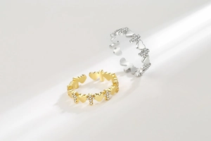 Detail of silver and gold open rings with heart and cross patterns set with tiny zircons