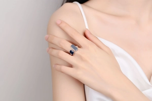 Detail of minimalist open ring featuring blue enamel geometric shapes on a female hand