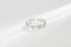 Macro detail of silver adjustable ring featuring hollow heart and crystal pavé cross