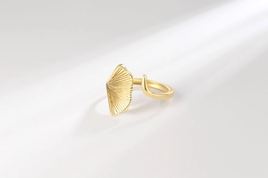 Macro detail of golden ginkgo leaf ring with fine radial textures on a white background