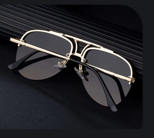 Detailed close-up of double-bridge gold metal aviator sunglasses with dark grey lenses