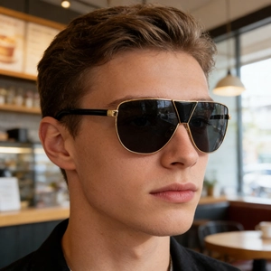 Gros plan sur des lunettes de soleil aviateur dorées pour homme avec verres foncés à l'extérieur
