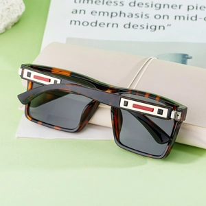 Detail of tortoise square sunglasses with gold metal temples and red enamel inlay