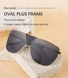 Vue détaillée des lunettes de soleil ovales en métal noir sur socle en pierre