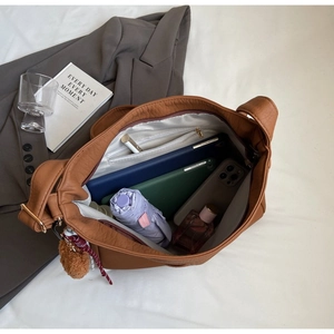 Detailed view of spacious interior with organizer pockets and cute bear charm accent