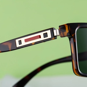 Detailed macro shot of vintage tortoise sunglasses featuring golden geometric temple inlays
