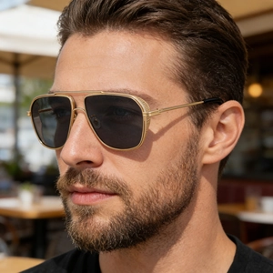 Detail of gold metal frame square sunglasses with textured side temples on a male model