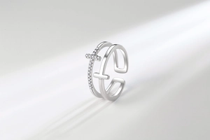 Macro detail of double-layered silver cross ring with pavé-set clear zircon crystals