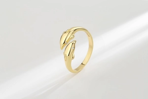 Close-up of golden double dolphin ring with S925 hallmark and sparkling gemstone eyes