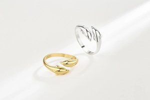 Detailed close-up of gold and silver dolphin rings with sparkling zircon stone eyes