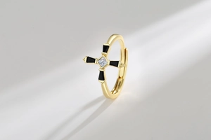 Detailed macro of gold cross ring with black enamel and square zircon centerpiece