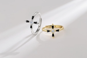 Macro detail of cross ring with square zircon and black enamel in gold and silver finish