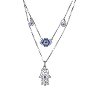 Macro detail of silver double-layered necklace with Hamsa hand and Evil Eye charms