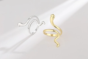 Detailed close-up of vintage snake rings in polished gold and silver minimalist finishes