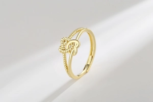 Detail of twisted rope and smooth gold bands forming a double heart knot on a ring